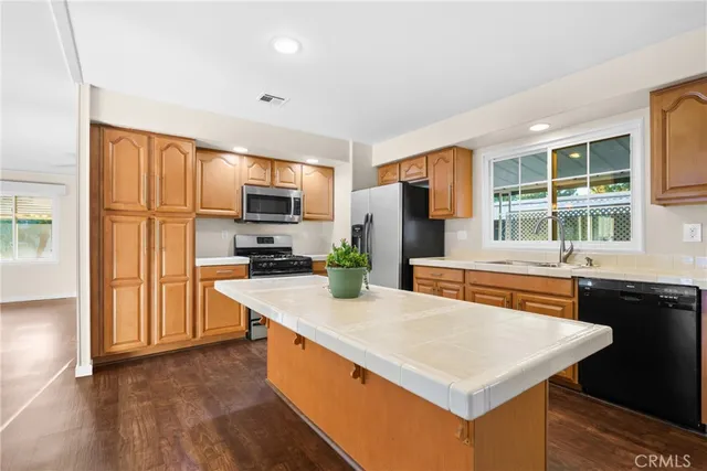 a kitchen with stainless steel appliances a stove top oven a sink refrigerator and microwave