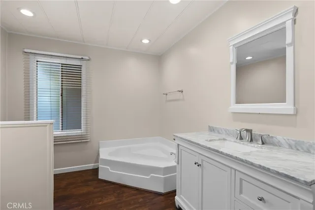 a bathroom with a granite countertop sink and a bathtub