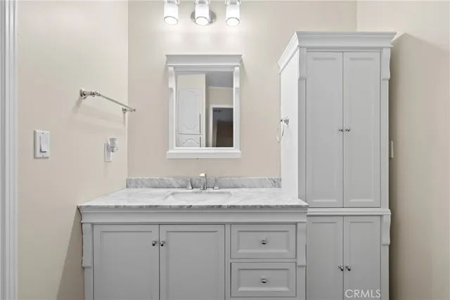 a bathroom with a granite countertop sink and a mirror