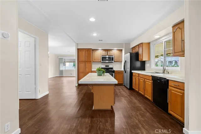 a large kitchen with stainless steel appliances granite countertop a lot of counter space and wooden floor