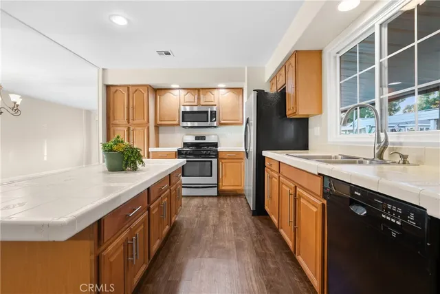 a kitchen with kitchen island granite countertop a sink appliances cabinets and a counter top space
