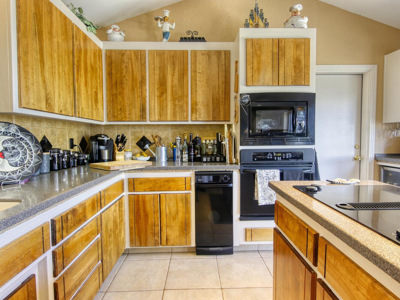 23760 El Rancho Drive Tehachapi, CA 93561 - Photo 18 of 40 a kitchen with stainless steel appliances granite countertop a stove a sink and a microwave