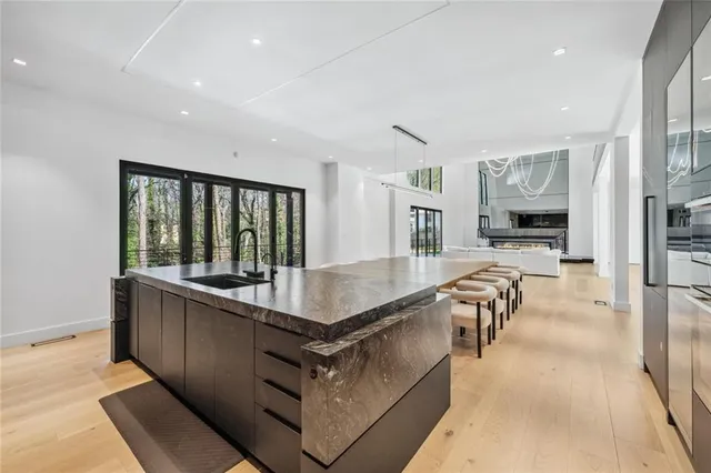 a living room with stainless steel appliances granite countertop furniture a sink a counter top and a view of living room