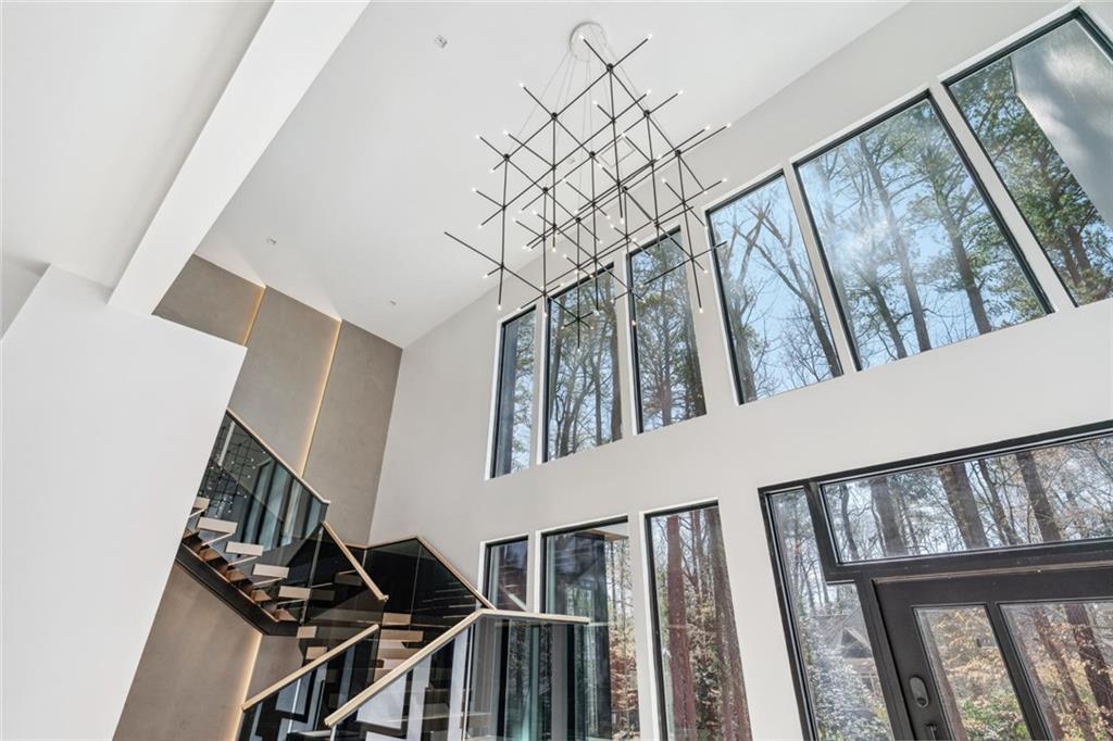 1355 Moores Mill Road Northwest Atlanta, GA 30327 - Photo 16 of 45 a view of staircase with lots of frames on wall and a large window