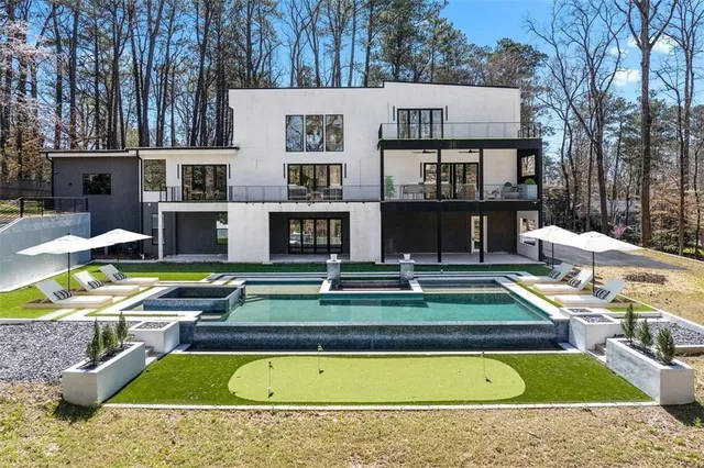 a view of a house with swimming pool and sitting area