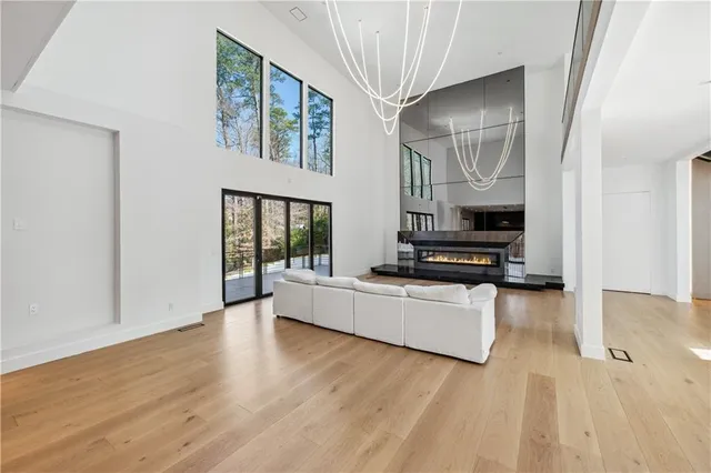 a living room with stainless steel appliances kitchen island hardwood floor and a sink