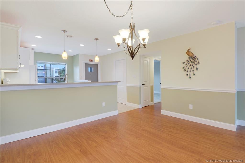 1864 Southwest Palm City Road, Unit 202 Stuart, FL 34994 - Photo 9 of 29 a view of a kitchen with wooden floor and a chandelier
