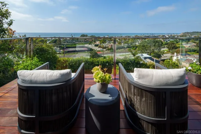 a view of a balcony with chairs and a potted plant