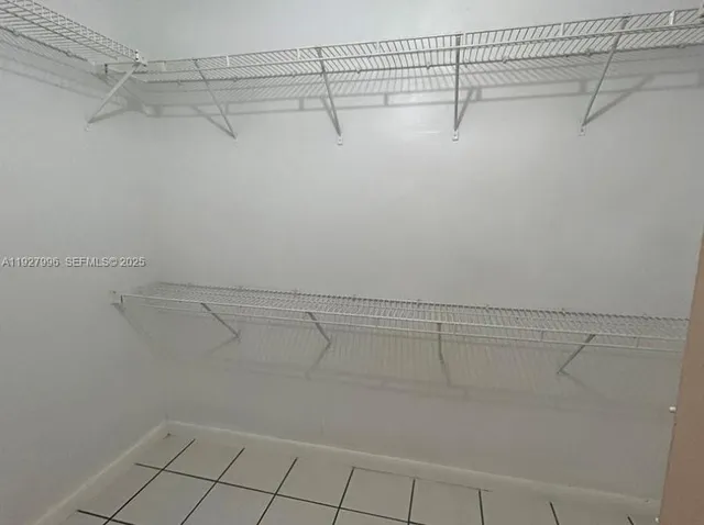 a view of a livingroom with a chandelier fan and window