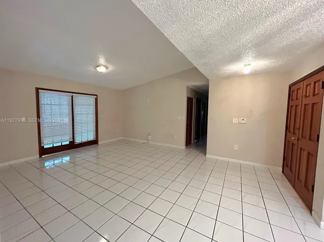 a large white kitchen with a stove a refrigerator and a sink