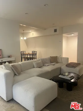 a living room with furniture a flat screen tv and a window