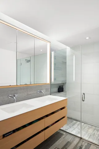 a bathroom with a sink mirror and a shower