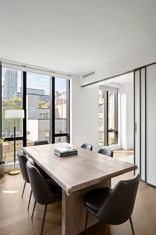 a kitchen with stainless steel appliances granite countertop a stove a refrigerator a white table and chairs with wooden floor