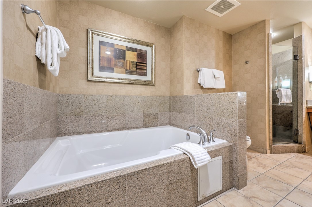 211 East Flamingo Road, Unit 1402 Las Vegas, NV 89169 - Photo 25 of 43 Full bath with a shower stall, a garden tub, tile walls, and tile patterned floors