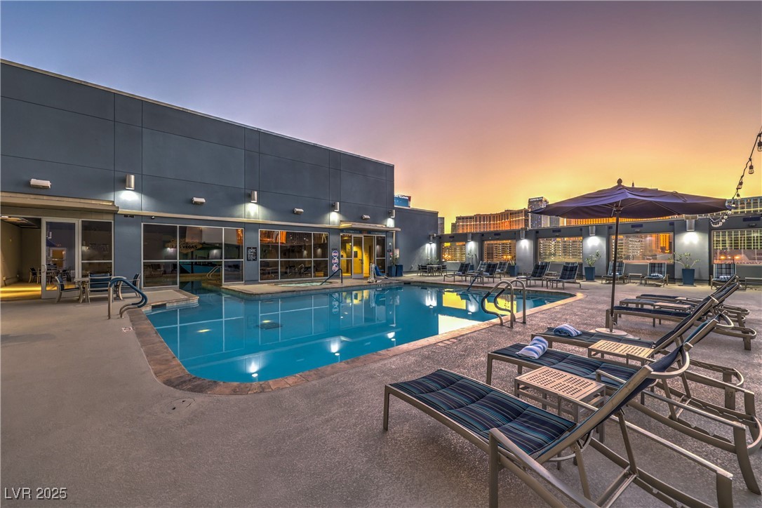 211 East Flamingo Road, Unit 1402 Las Vegas, NV 89169 - Photo 36 of 43 Pool at dusk with a community pool and a patio
