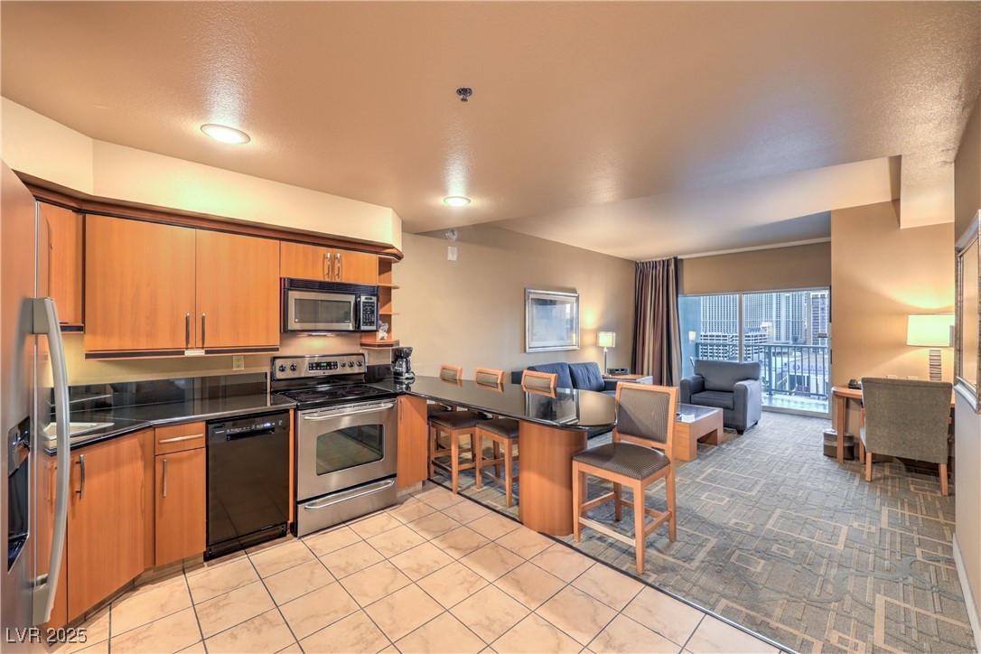 211 East Flamingo Road, Unit 1402 Las Vegas, NV 89169 - Photo 43 of 43 Kitchen featuring stainless steel appliances, brown cabinetry, a kitchen breakfast bar, a peninsula, and open floor plan