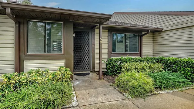 a front view of a house with a lots of flowers