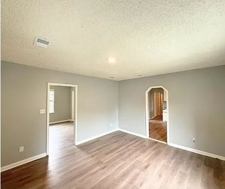 an empty room with wooden floor and closet