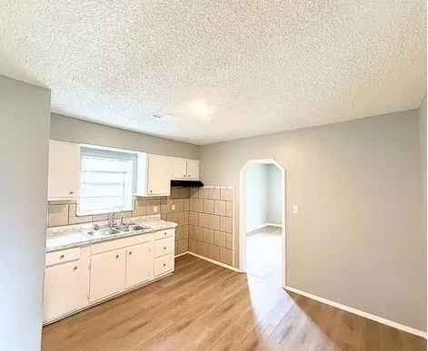 a kitchen with granite countertop white cabinets and white appliances