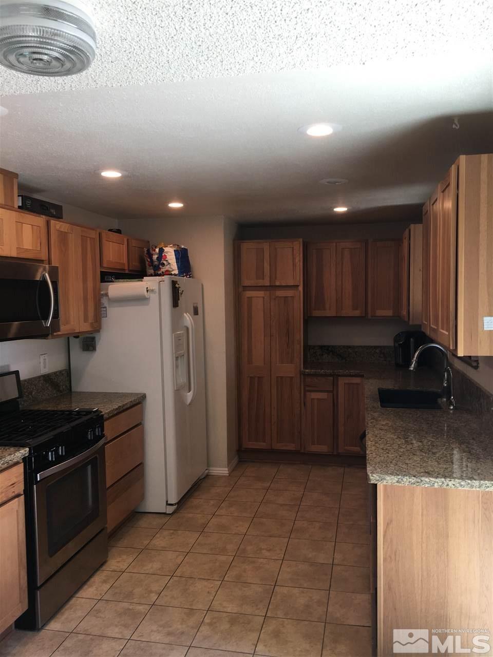 10003 Albite Street Reno, NV 89506 - Photo 23 of 25 a kitchen with a refrigerator sink and cabinets