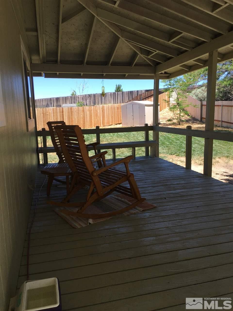 10003 Albite Street Reno, NV 89506 - Photo 10 of 25 a view of patio with table and chairs under an umbrella with a small yard