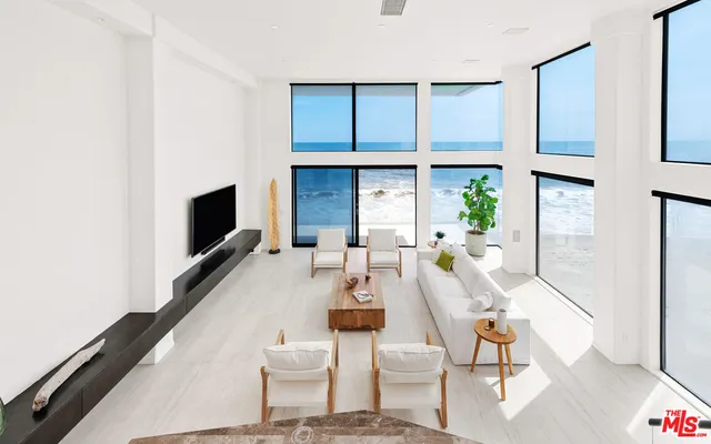 a living room with furniture a flat screen tv and kitchen view