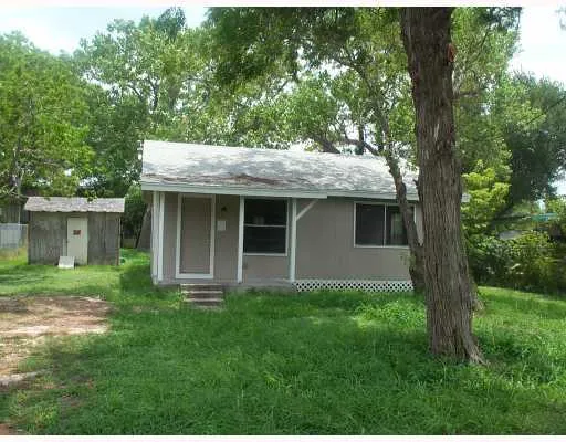 a view of a house with a yard and large tree