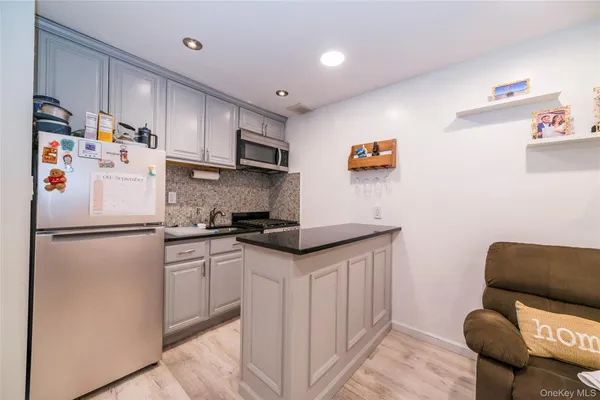 a kitchen with stainless steel appliances granite countertop a refrigerator sink stove and white cabinets