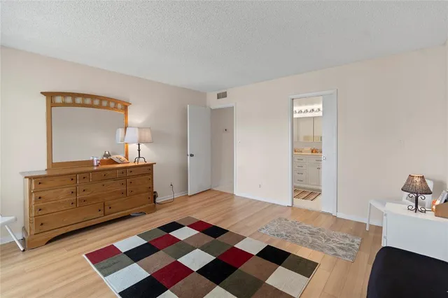 a bedroom with a bed and a mirror on dresser