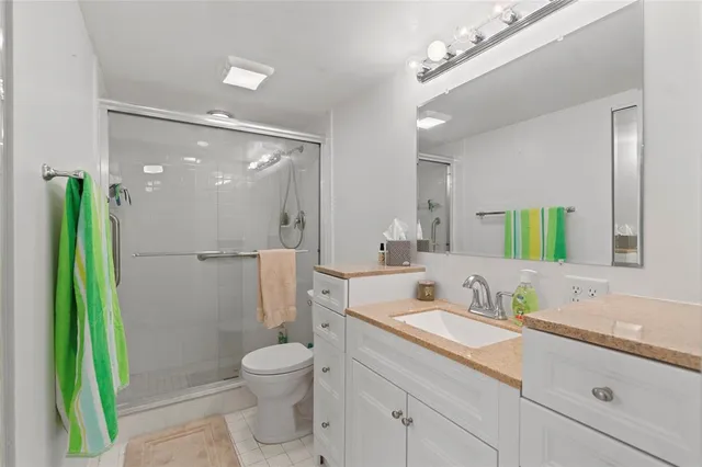 a bathroom with a granite countertop sink toilet and shower
