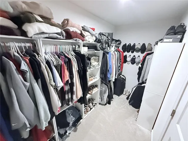 a view of walk in closet with clothes