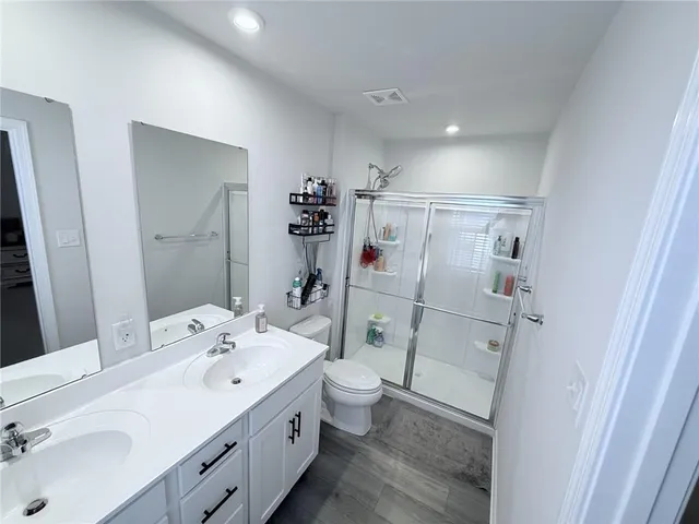 a bathroom with a double vanity sink mirror and toilet