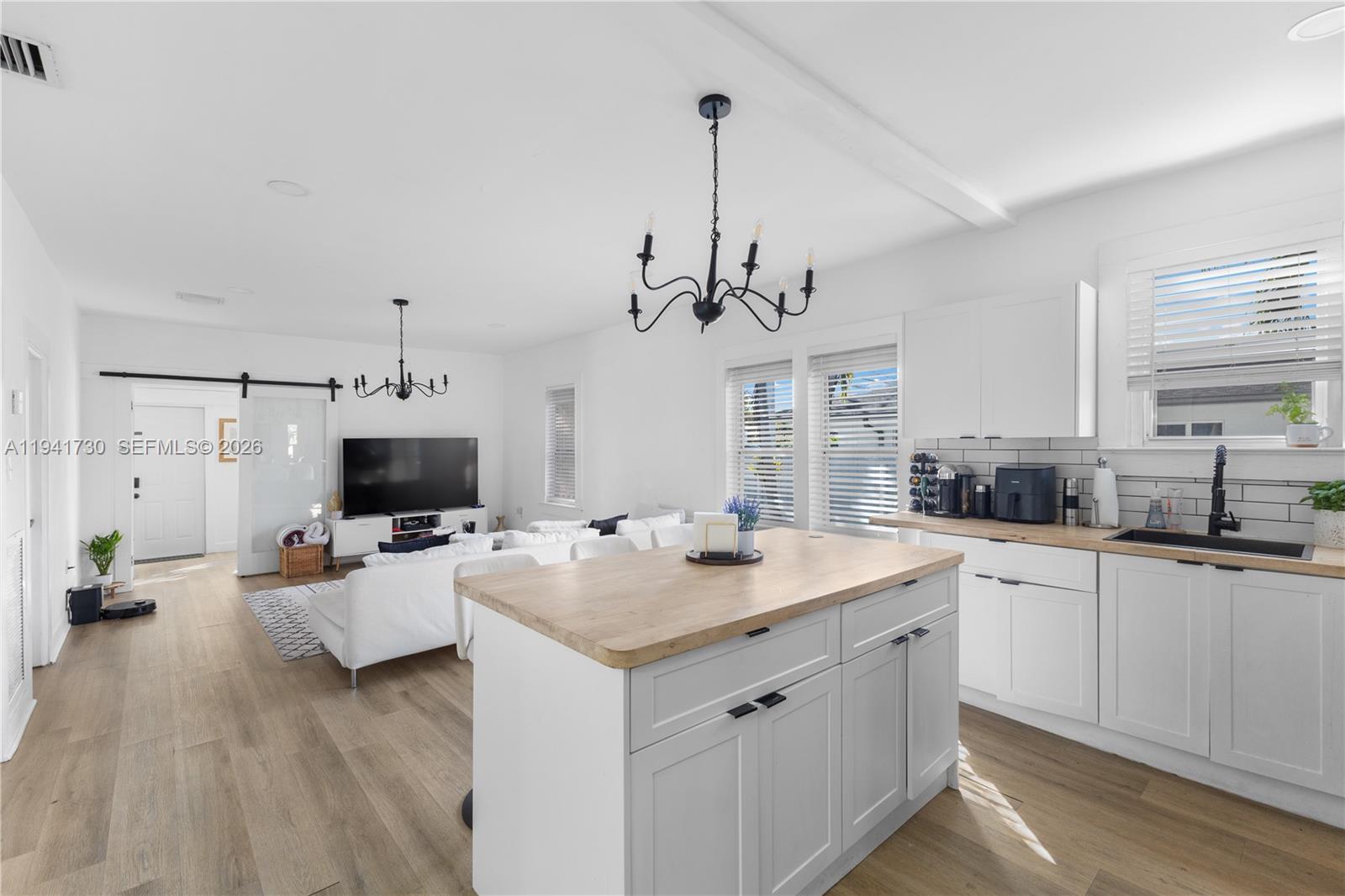 2811 Southwest 17th Street Miami, FL 33145 - Photo 13 of 36 a view of a kitchen counter space a sink wooden floor and a chandelier