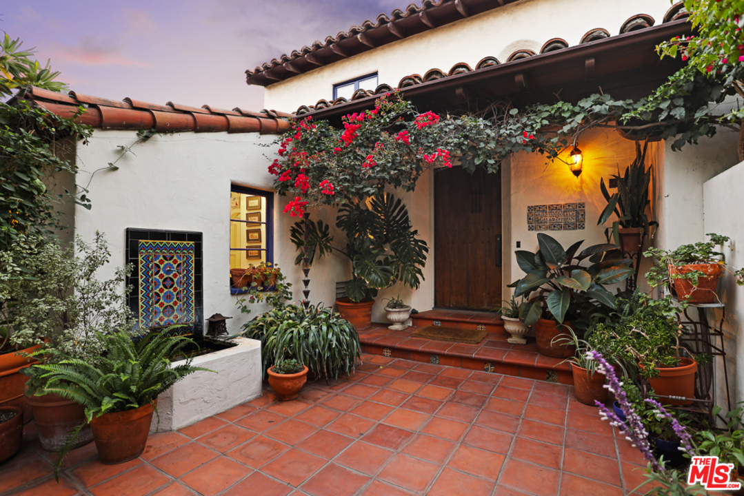 3892 Franklin Avenue Los Angeles, CA 90027 - Photo 1 of 37 a vase of flowers sitting on a sidewalk in front of a house