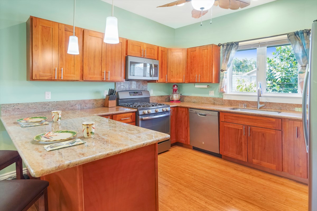 5273 Kawaihau Road, Unit 1 Kapaa, HI 96746 - Photo 2 of 16 a kitchen with a sink a window and chairs