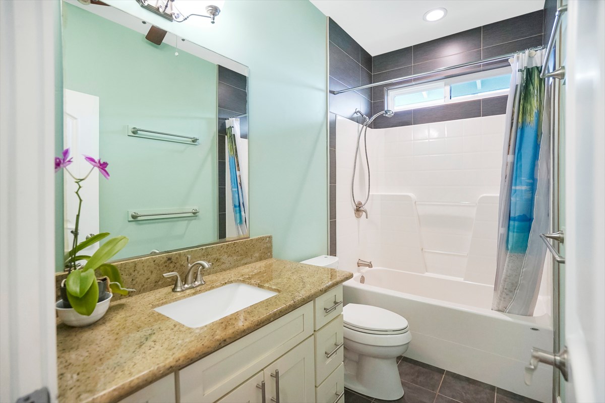 5273 Kawaihau Road, Unit 1 Kapaa, HI 96746 - Photo 9 of 16 a bathroom with a granite countertop sink toilet and shower