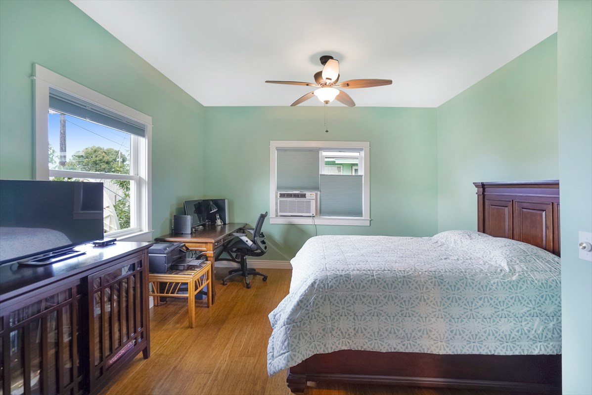 5273 Kawaihau Road, Unit 1 Kapaa, HI 96746 - Photo 10 of 16 a bedroom with a bed and wooden floor