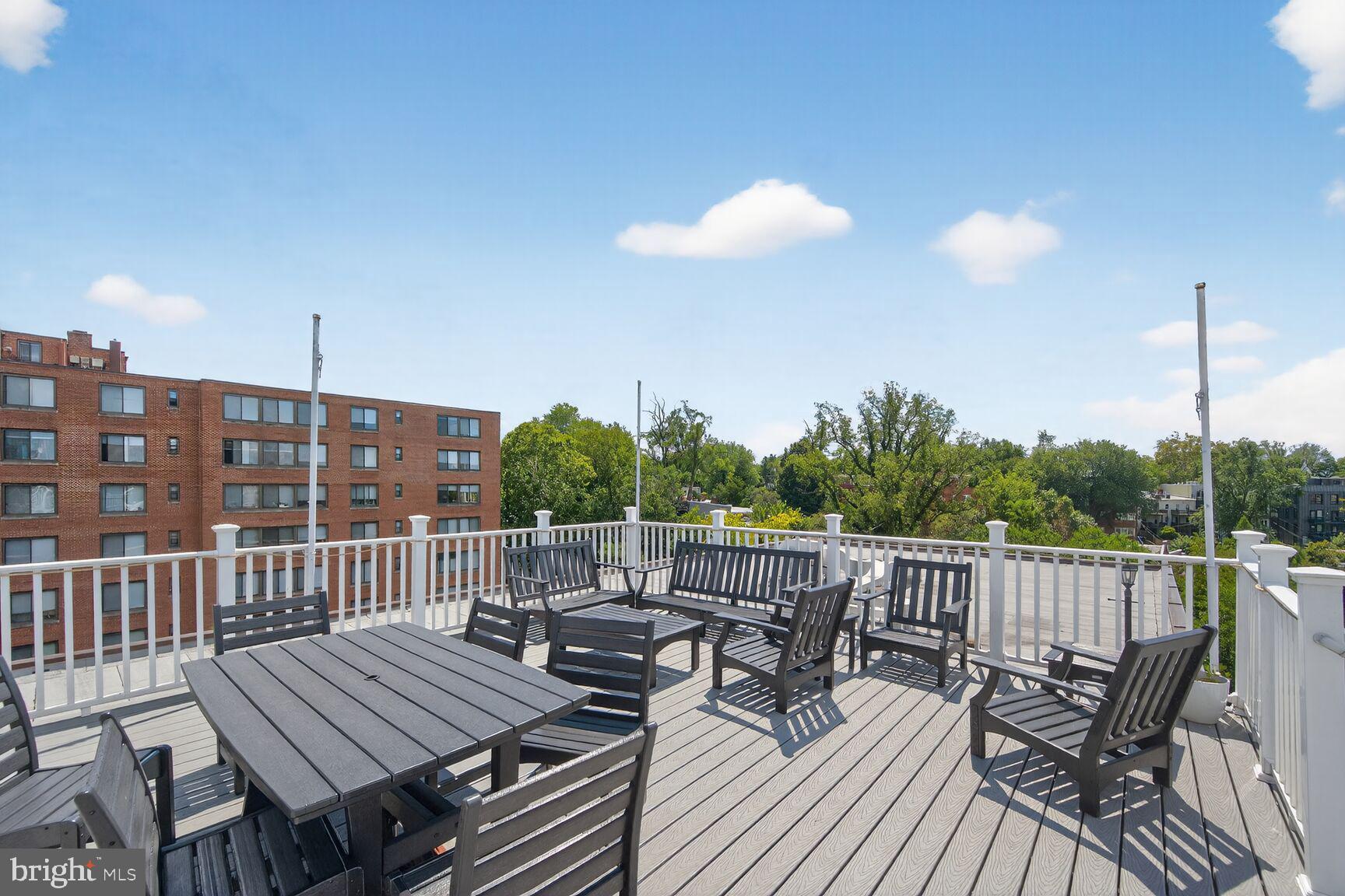 3900 Tunlaw Road Northwest, Unit 103 Washington, DC 20007 - Photo 24 of 41 a view of a roof deck with table and chairs with wooden floor