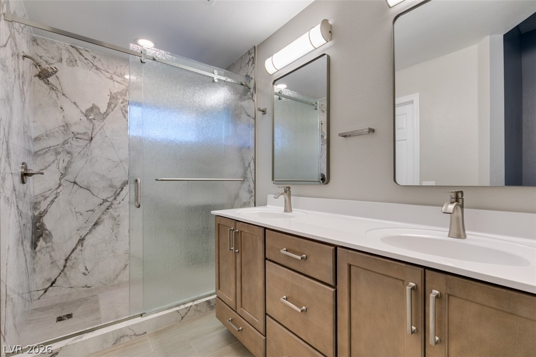 540 Sutters Mill Road Henderson, NV 89014 - Photo 4 of 46 This primary bathroom features a double vanity and a glass-enclosed shower, creating a bright and functional space.