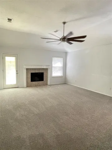 an empty room with windows and fireplace