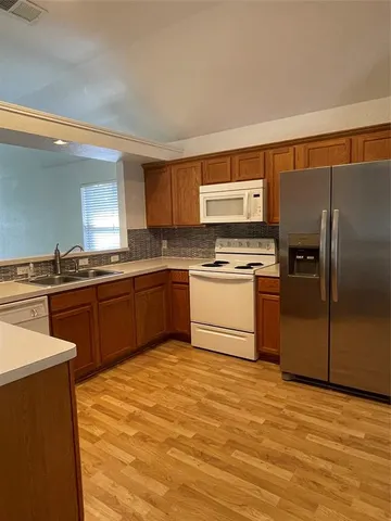 a kitchen with stainless steel appliances granite countertop a stove a sink and a refrigerator
