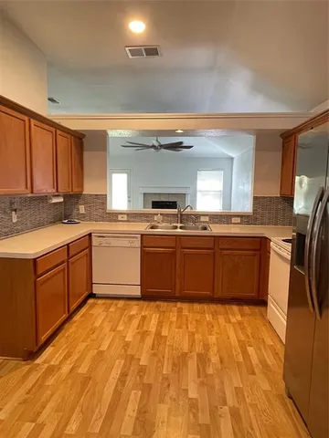 a kitchen with stainless steel appliances granite countertop a stove a sink dishwasher and a refrigerator