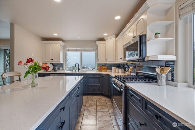 a kitchen with kitchen island granite countertop a sink counter top space appliances and cabinets