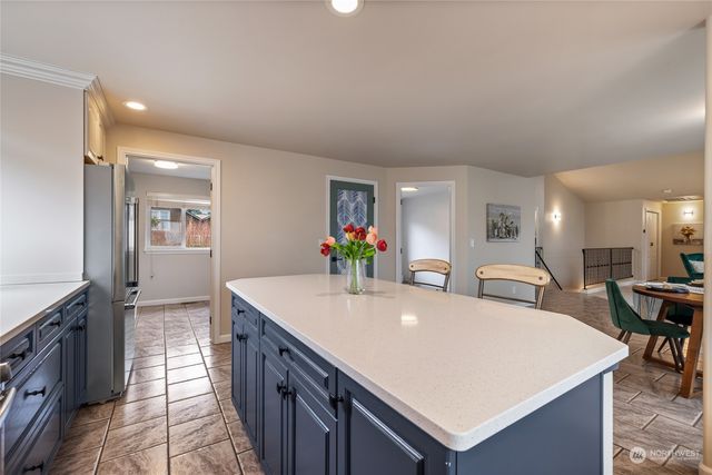 a large white kitchen with a sink and dishwasher a stove top oven with wooden floor