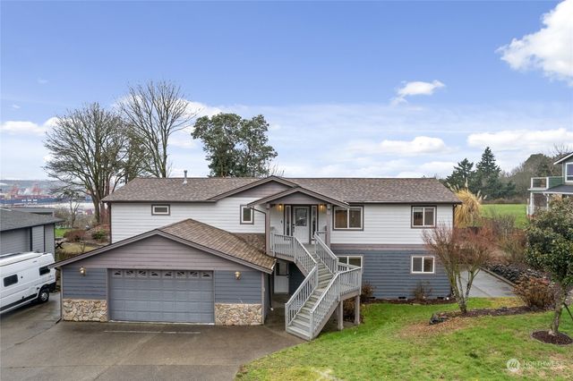 a front view of a house with a garden and trees