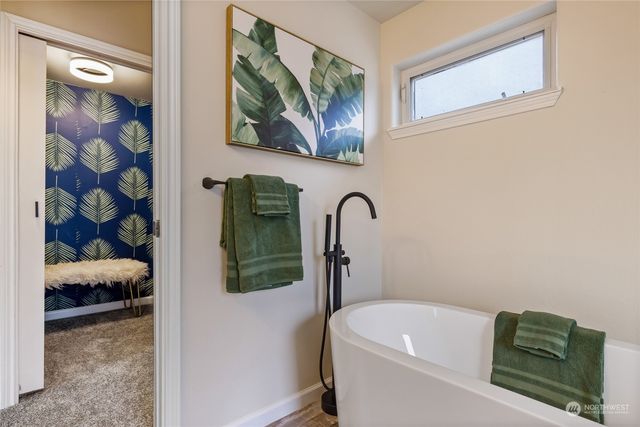 a bathroom with a tub and a painting on the wall
