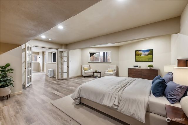 a bedroom with a large bed couches and a flat tv screen