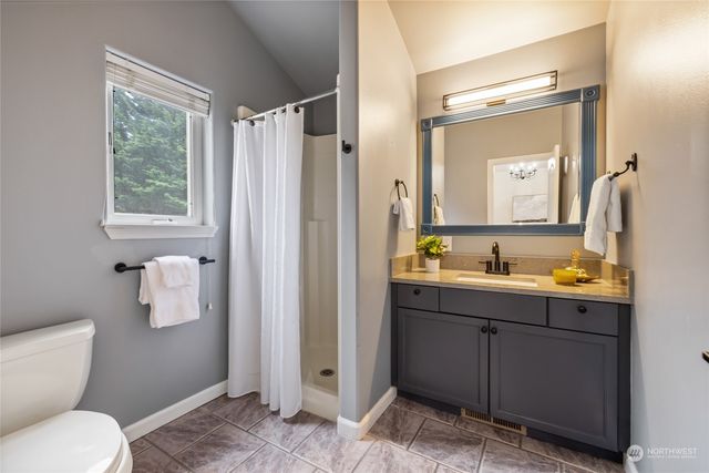 a bathroom with a toilet a sink and mirror