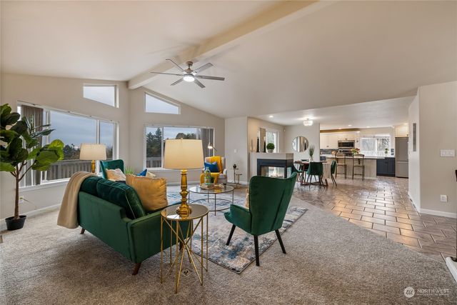 a living room with furniture and a view of kitchen