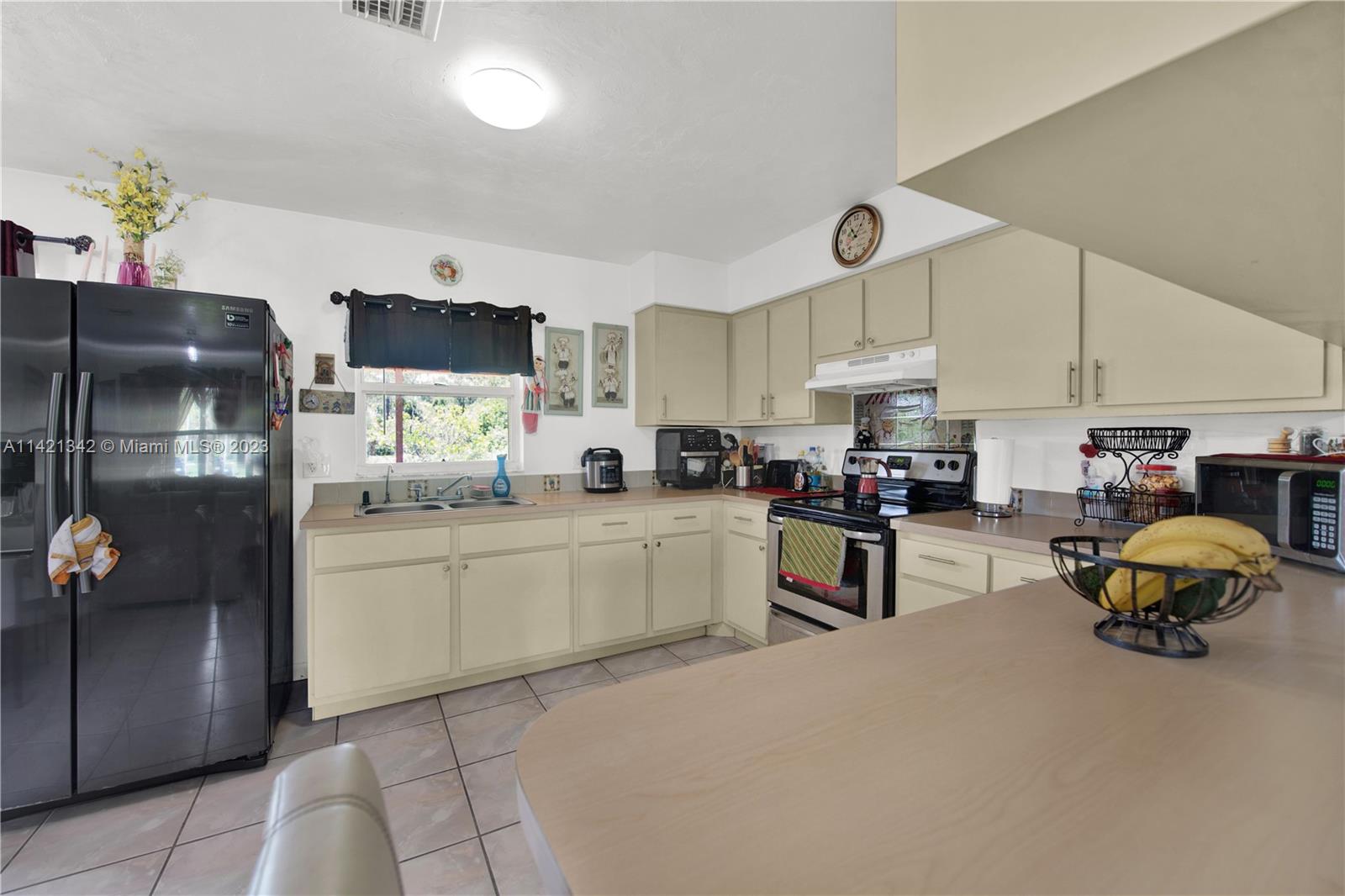 1480 Southwest 17th Street Naples, FL 34117 - Photo 11 of 36 a kitchen with stainless steel appliances kitchen island granite countertop a refrigerator and microwave